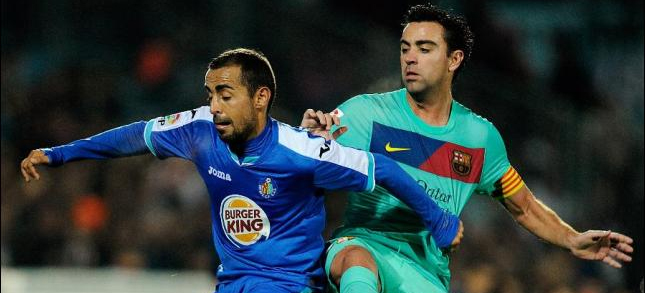 Xavi Hernández pugna por un balón